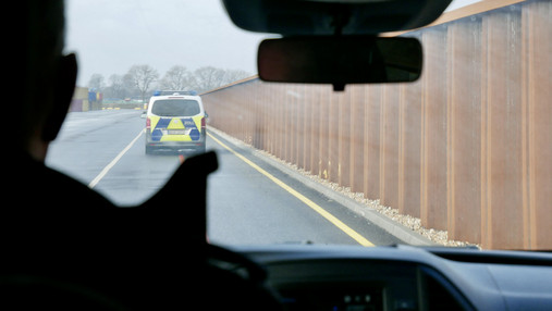 Mit dem Zoll im Hamburger Hafen - Anfahrt Foto zum Thema „Zoll Hamburger Hafen“: Zu sehen ist, wie Felix den Streifenwagen steuert. Es ist nur sein Umriss zu erkennen.