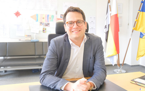 Benjamin Fadavian - am Schreibtisch Zu sehen ist ein Foto von Benjamin Fadavian. Er sitzt am Schreibtisch.