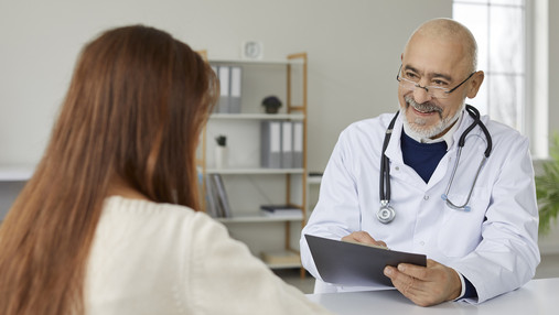 Der Weg zur passenden Krankenversicherung Foto zum Thema "der passende Weg zur Krankenversicherung": Zu sehe ist ein Arzt, der sich im Gespräch mit einer Patientin befindet.
