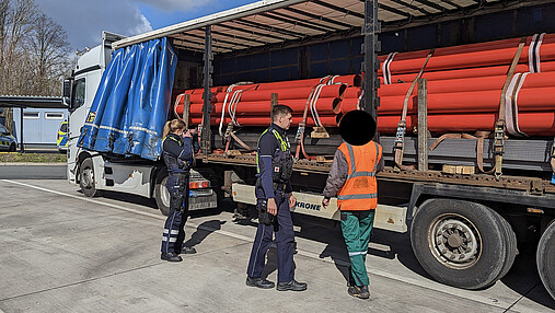 Foto zum Thema "Wie wird man Polizist*in": Zu sehen sind Svenja und ihr Kollege bei einer LKW-Kontrolle auf einem Autobahnparkplatz.