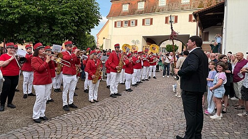 Foto zum Thema "Wie wird man Bürgermeister": Rechts im Bild steht Joachim, links spielt eine Musikkapelle.