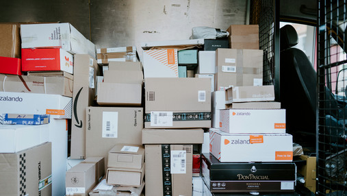 Probleme in der Paketzustellung - Gewerkschaften fordern Reformen Foto zum Thema Probleme in der Paketzustellung: Zu sehen ist der Innenraum eines Zustellfahrzeugs, in dem sich sehr viele Pakete befinden.