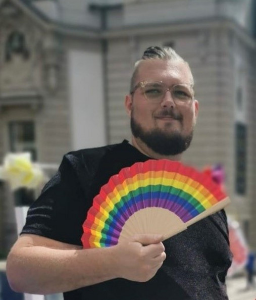 Coming-out am Arbeitsplatz - Henning Klemme zeigt klare Kante Foto zum Thema Coming-out am Arbeitsplatz: Zu sehen ist Henning Klemme von der AG Diversity der dbb jugend mit einem Regenbogen-Fächer in der Hand.