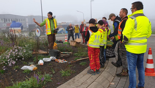 Klimaschutz in der Kommune - Pflanzaktion Foto zum Thema mehr Klimaschutz in der Kommune: Zu sehen ist eine Gruppe Menschen, die eine Blühwiese anlegt.