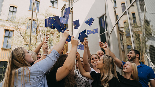 Das Foto zeigt Mitglieder der dbb jugend, die europäische Fahnen schwingen.