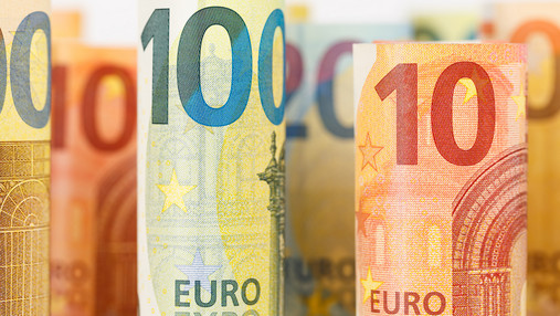 Beamtenkredite - mit Überblick und Strategie Foto zum Thema "Beamtenkredite": Zu sehen sind zusammengerollte Banknoten, 100 Euro- sowie Zehn-Euro-Scheine.