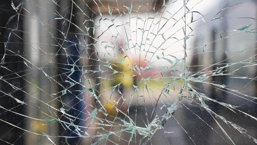 Gewalt gegen Beschäftigte im öffentlichen Dienst Foto zum Thema "Gewalt gegen Beschäftigte im öffentlichen Dienst": Zu sehen ist eine zersprungene Scheibe.