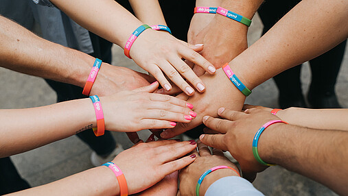 Das Foto zeigt Hände von Mitgliedern der dbb jugend, die übereinanderliegen und Zusammenhalt symbolisieren.
